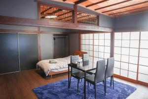 a room with a table and chairs and a bed at Udo Torii Gate Stay Yoi in Nichinan
