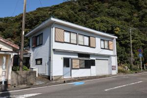 a white house on the side of a street at Udo Torii Gate Stay Yoi in Nichinan