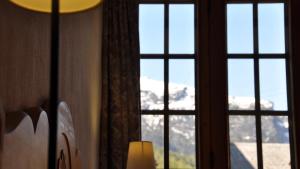 a window with a view of a snow covered mountain at Chalet Goldblick in Grächen