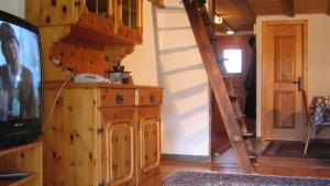 a living room with a tv and a staircase at Chalet Goldblick in Grächen