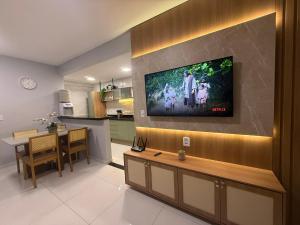 a living room with a television on a wall at Lençois Confort in Barreirinhas
