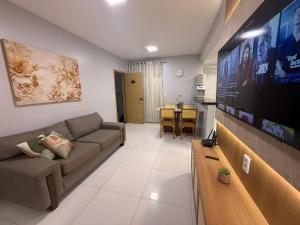 a living room with a couch and a flat screen tv at Lençois Confort in Barreirinhas