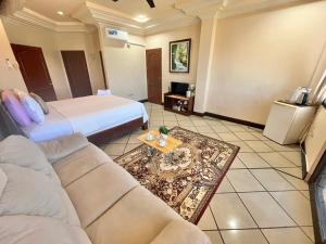 a hotel room with a bed and a couch at Casaroyal Beachfront Siquijor in Siquijor