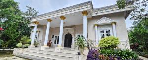 a large white house with columns and stairs at Vila Graha Wisesa 3 in Kacomberan