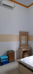 a bedroom with luggage and a bed and a desk at Vila Graha Wisesa 3 in Kacomberan
