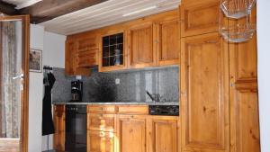 a kitchen with wooden cabinets and a stove at Chalet Goldblick in Grächen