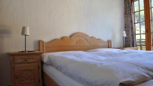 a bedroom with a large bed with a wooden headboard at Chalet Goldblick in Grächen