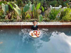 a young boy in a bowl of fruit in a swimming pool at Vila Graha Wisesa 3 in Kacomberan
