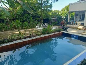 a swimming pool in a yard with a house at Vila Graha Wisesa 3 in Kacomberan