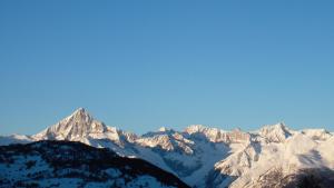 a view of a mountain range with snow covered mountains at Chalet Goldblick in Grächen