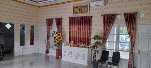 a living room with a table and chairs and windows at Vila Graha Wisesa 3 in Kacomberan +43 photos