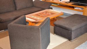 a living room with a couch and a table and a stool at Chalet Goldblick in Grächen