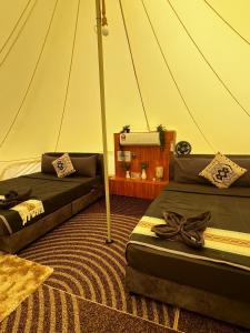 a room with two beds in a tent at bira pata glamping in Marang