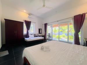 a bedroom with a large bed and a window at Terrace Resort in Phú Quốc