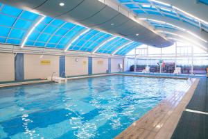 a swimming pool with blue water in a building at C&D Hotel Quanzhou in Quanzhou