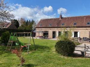 a yard with a swing in front of a house at Maison ancienne avec sauna et jeux au cœur du Perche - FR-1-497-51 in Moussonvilliers