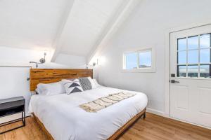 a white bedroom with a large bed and a window at Tidal House #6 - Ocean Shores Chalet in Ocean Shores