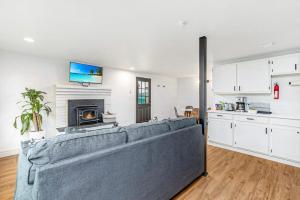 a living room with a large couch and a kitchen at Tidal House #6 - Ocean Shores Chalet in Ocean Shores