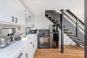 a kitchen with white cabinets and a staircase at Tidal House #6 - Ocean Shores Chalet in Ocean Shores +12 photos