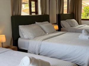 a hotel room with two beds with white sheets at Hostel Once Once in Villa de Leyva +41 photos