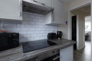 a kitchen with a counter top and a black appliance at Anderson Apartment in Airdrie