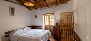 a bedroom with a bed and a window at ollanta lodge in Ollantaytambo