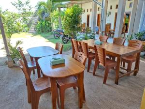 a patio with wooden tables and wooden chairs at Golo Tango Homestay in Labuan Bajo