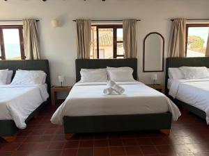 a bedroom with two beds with a teddy bear on the bed at Hostel Once Once in Villa de Leyva