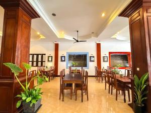 a dining room with wooden tables and chairs at VPlus Hotel in Siem Reap