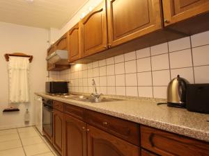 a kitchen with wooden cabinets and a sink at Reihenhäuser in Strackholt in Strackholt
