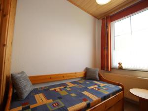 a small bedroom with a bed and a window at Reihenhäuser in Strackholt in Strackholt +28 photos