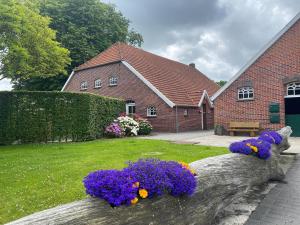 a house with flowers on a log in the yard at Reihenhäuser in Strackholt in Strackholt