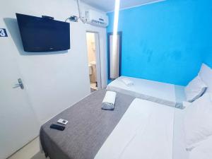 a room with a bed with a tv on the wall at Pousada Sol e Mar de Pajuçara in Maceió