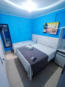 a bedroom with two beds with blue walls at Pousada Sol e Mar de Pajuçara in Maceió