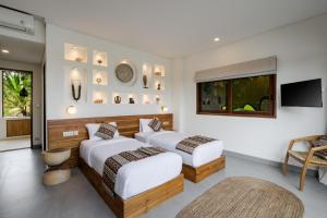 two beds in a room with a tv and a couch at Villa Fafa by BaliSuperHost in Ubud