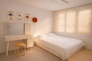 a bedroom with a bed and a desk and a chair at Sejong Hygge Stay in Sejong