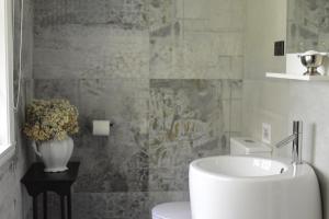 a bathroom with a sink and a vase of flowers at Juniper & Rye cottage for two in Ferny Creek +25 photos