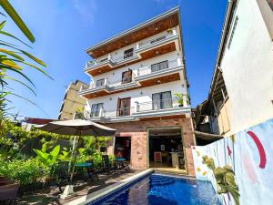 a hotel with a swimming pool in front of a building at VPlus Hotel in Siem Reap