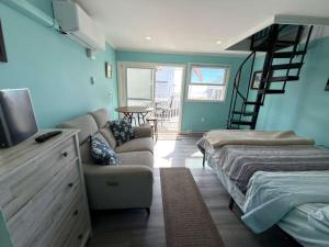a room with a couch and a bed and a staircase at Oceanview Loft York in York