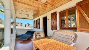 a porch with a wooden table and chairs at The Cliffs - Casa Alecrin in O Vicedo