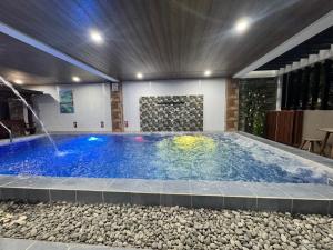 a swimming pool with a water fountain in a building at Southsea Staycation-couple in Nasugbu