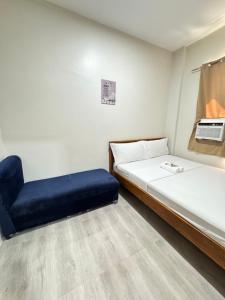 a small room with two beds and a blue chair at Southsea Staycation-couple in Nasugbu
