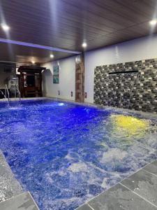 a large pool with blue water in a building at Southsea Staycation-couple in Nasugbu +9 photos