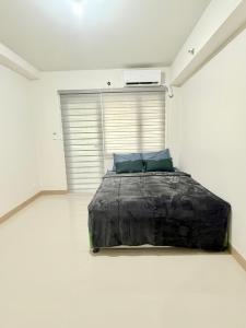 a bedroom with a large bed in a white room at Mattys Crib Tower C Unit 204 in Iloilo City +8 photos