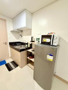 a small kitchen with a refrigerator and a sink at Mattys Crib Tower C Unit 204 in Iloilo City