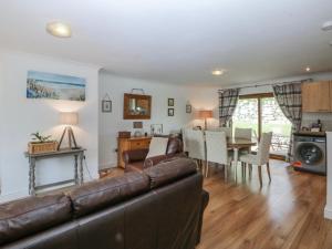 a living room with a couch and a dining room at Tŷ Gareg in Gaerwen