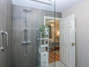 a bathroom with a shower with a glass door at Tŷ Gareg in Gaerwen +18 photos