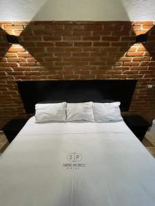 a white bed with two pillows on top of it at Hotel sueño pacifico in Entabladero