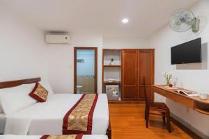 a bedroom with a bed and a desk with a computer at Liên Hương Hotel Đà Lạt in Kon Rung (1)