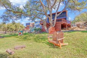 a bench sitting in the grass in front of a house at Bee Happy at the Lake in Canyon Lake